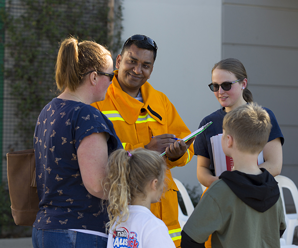 Volunteers talking to mum and kids