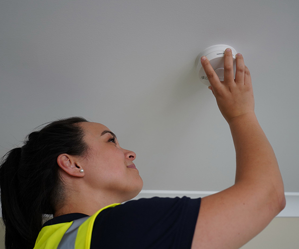 Lady checking smoke alarms