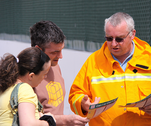 Volunteer showing flyer to members of the public