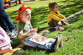 Child sitting on grass with cut-out activity