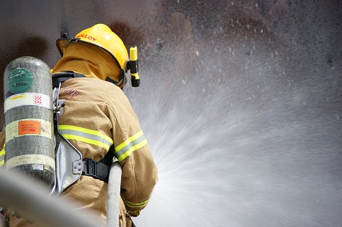 Firefighter with hose and water spraying