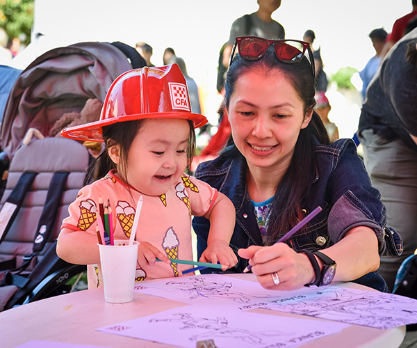 Lady with child wearing CFA hat colouring