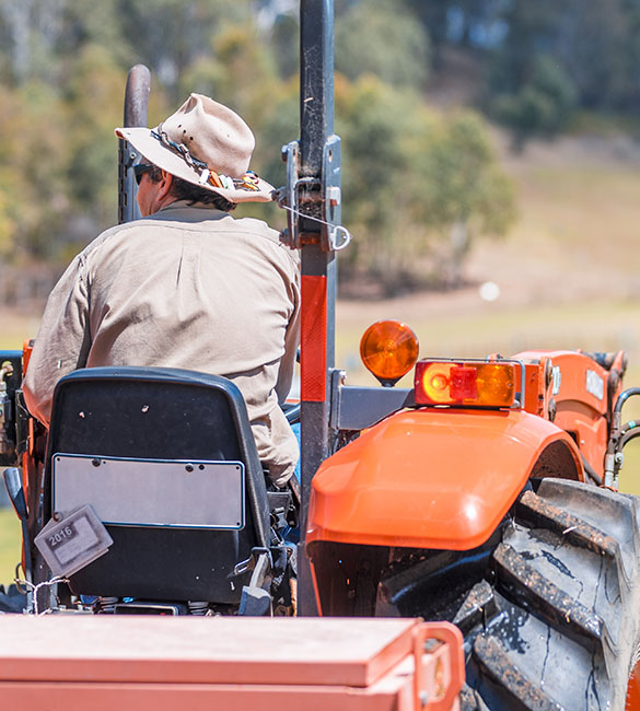farmer-on-tractor-in-farm-yard-460x500px