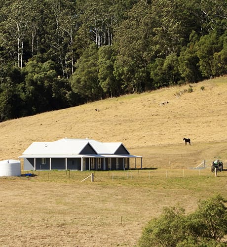 farmhouse on hill near bush 460x500px 