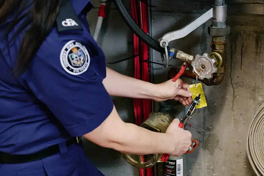 A fire hose reel tag being updated by a CFA fire equipment officer.