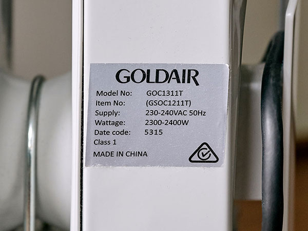 Close-up of a metallic silver product label on a white electrical appliance, showing the product specifications.