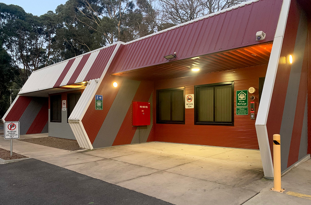 An angular building with a maroon and white paint design on the outside. It has windows, lights and signs identifying it as a CFR.