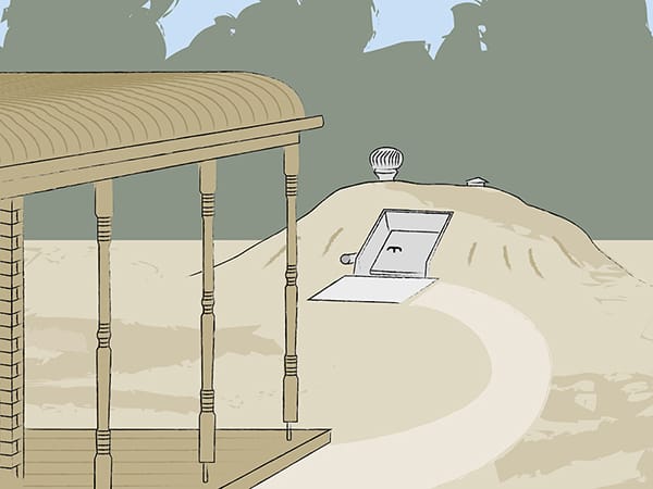 An in-ground bunker. In the foreground is the deck of the house. There is a path from the house to a small hill in the ground. On the side of the hill is a weather-sealed, fire-proof door and a vent.